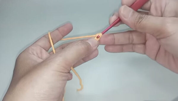 Making a magic ring with orange yarn and crochet hook