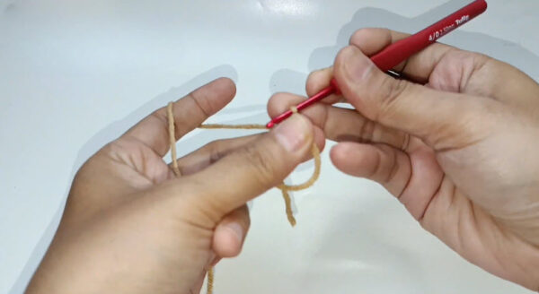 Making a magic ring with tan yarn and crochet hook