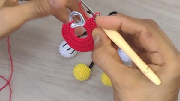 Adding stitches to red circular piece