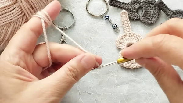 Crocheting guitar neck with pink yarn