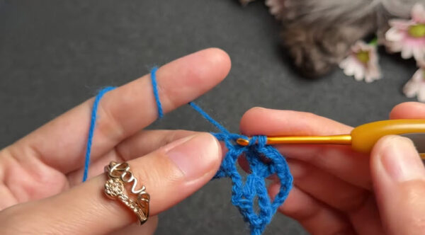 Double crochet forming petal shape in blue yarn