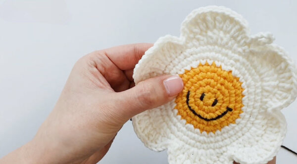 Embroidered smiley face on finished daisy pouch