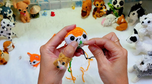 Embroidering the fox ring's face details.