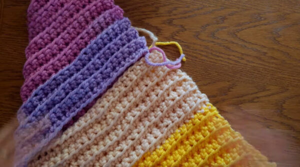 Folded crochet squares forming triangle shapes for the bag.