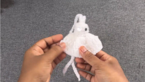 Holding completed white crochet ghost