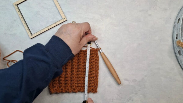 Measuring rust crochet swatch with ruler
