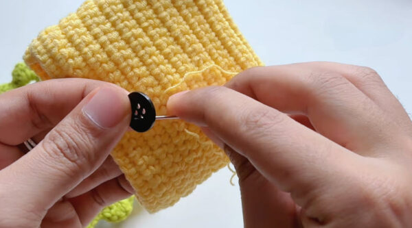 Sewing button onto crochet bag flap
