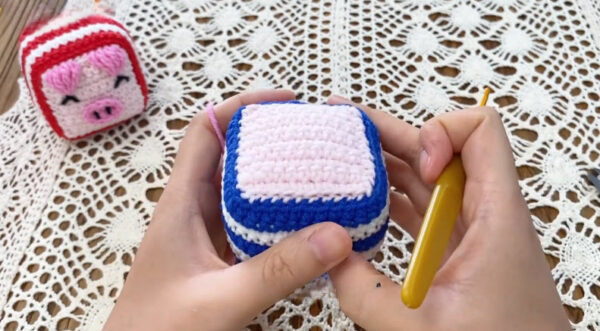 Sewing panel seam on crochet dice pig