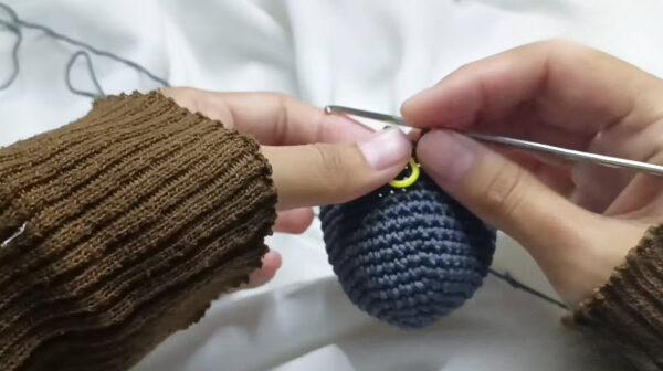 Stitch markers placed on the gray koala head before shaping.