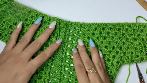 Two green crochet panels joined together at the seam.