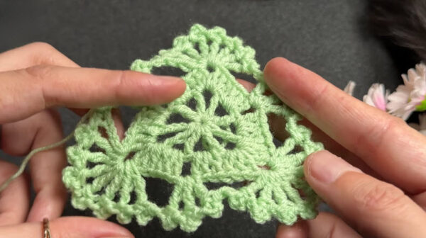 Two joined green crochet coaster motifs
