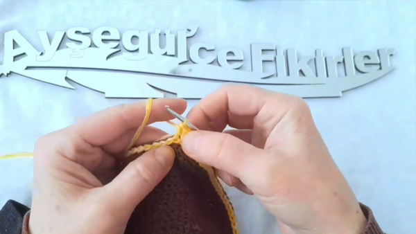 Attaching yellow yarn to the edge of the brown circle