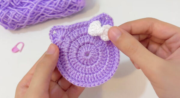 Finished purple cat face coaster with a small white bow.