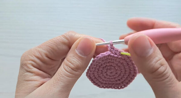 Flat pink circle worked in single crochet with a yellow marker.