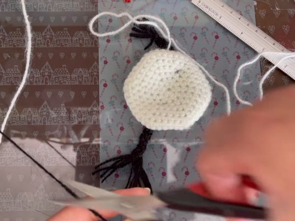 Black yarn strands attached to the white crochet piece