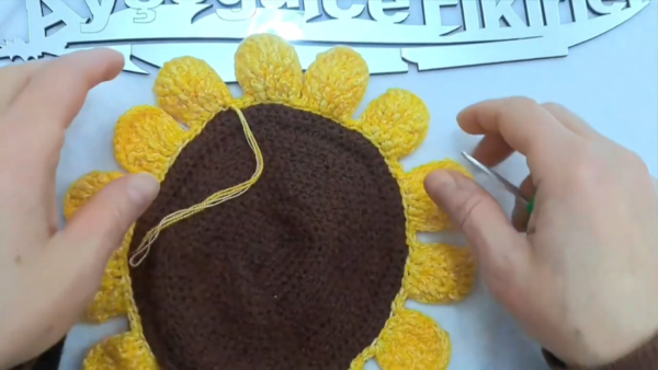Completed crochet sunflower wall hanging with yellow petals and brown center