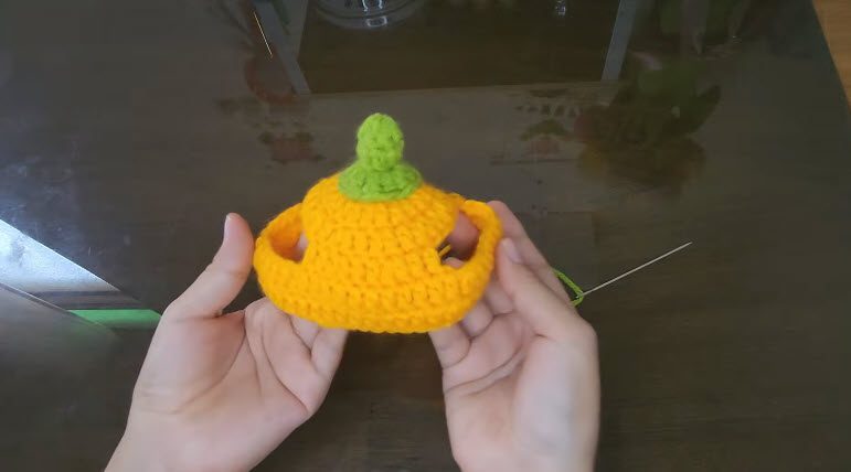 Green stem attached to the orange pumpkin hat