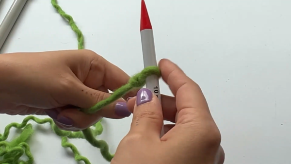 Slip knot on a straight needle to start a crochet chunky sweater