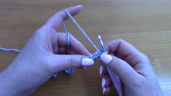 Making foundation chain stitches using light blue yarn.