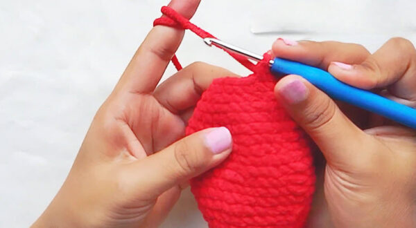 Crochet Spider-Man keychain step: red ball narrowing with decrease rounds on the hook