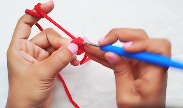 Crochet Spider-Man keychain step: red yarn magic ring started on a blue hook