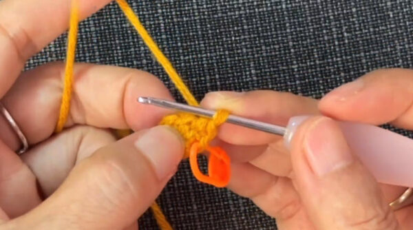 Round 2 of the yellow magic ring with single crochet increases