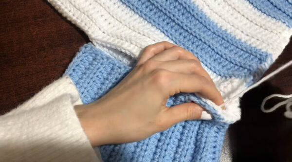 Seaming blue and white pieces of the crochet Argentina sweater