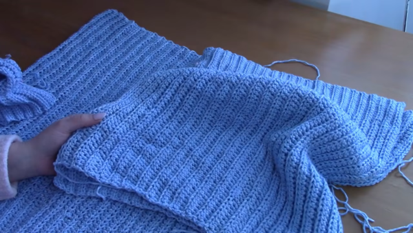 Seaming the sleeve to the cardigan shoulder panel.