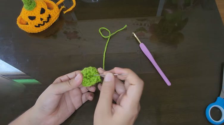 Sewing the green stem piece with a yarn needle
