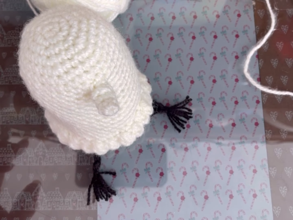 Side view of the Oyasumi Punpun amigurumi with black yarn details