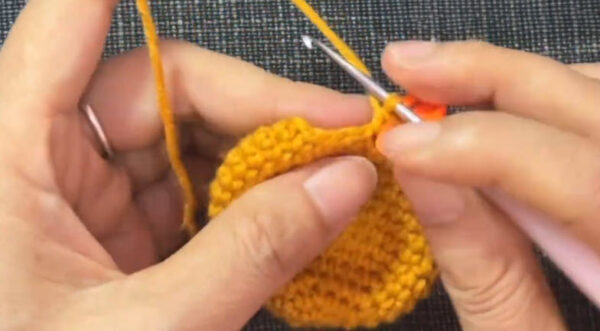 Stitches tighten as the yellow ball starts to close