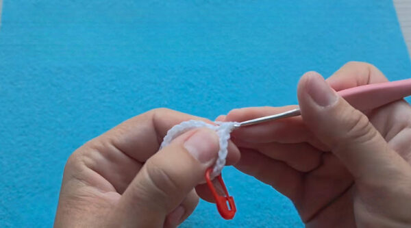 White ring with a red stitch marker clipped on for the crochet mushroom keychain