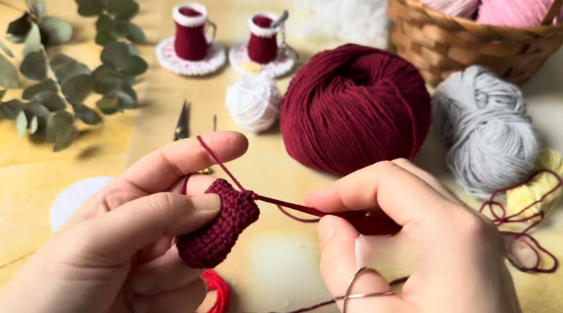 Working even rounds to build the burgundy cup wall of the crochet tea glass pattern.